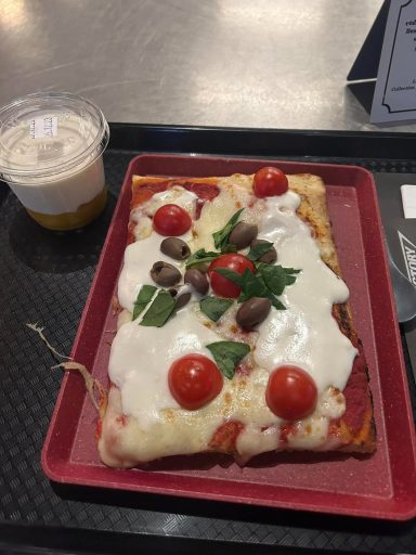 A square slice of pizza topped with cheese, tomatoes and olives