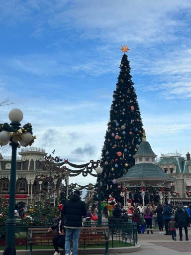 a large christmas tree with a gazebo in front of it