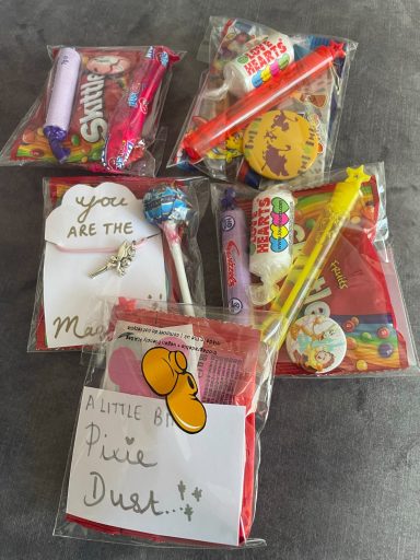 The image shows cellophane bags containing sweets, bubbles, stickers and bracelets