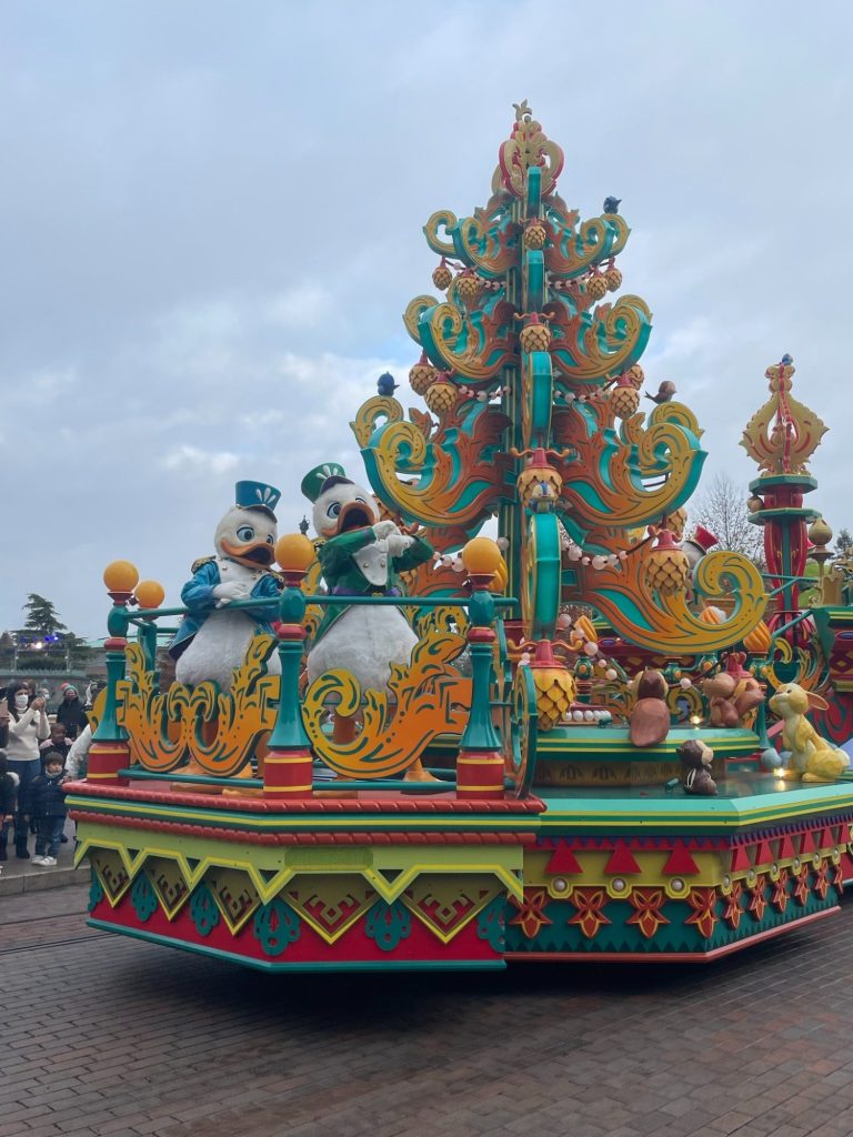 Donalds nephews waving from a float featuring a large christmas tree