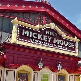 Image of the sign outside the meet mickey mouse location which is styled like a theatre and is red and cream