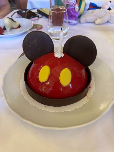 The mickey themed birthday cake, red with chocolate mouse ears and yellow chocolate buttons