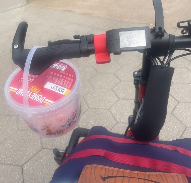 Image of the handlebars of the attachment with a bucket of candy floss hanging from it