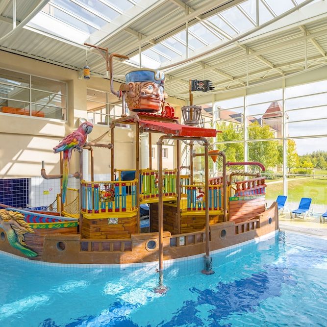 Image of the indoor pool at explorers hotel which features a pirate ship